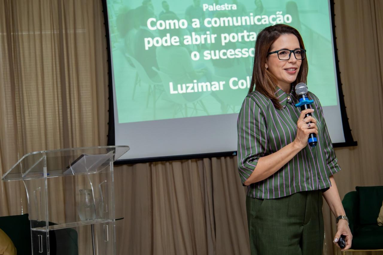 Luzimar Collares palestrando com microfone em evento corporativo