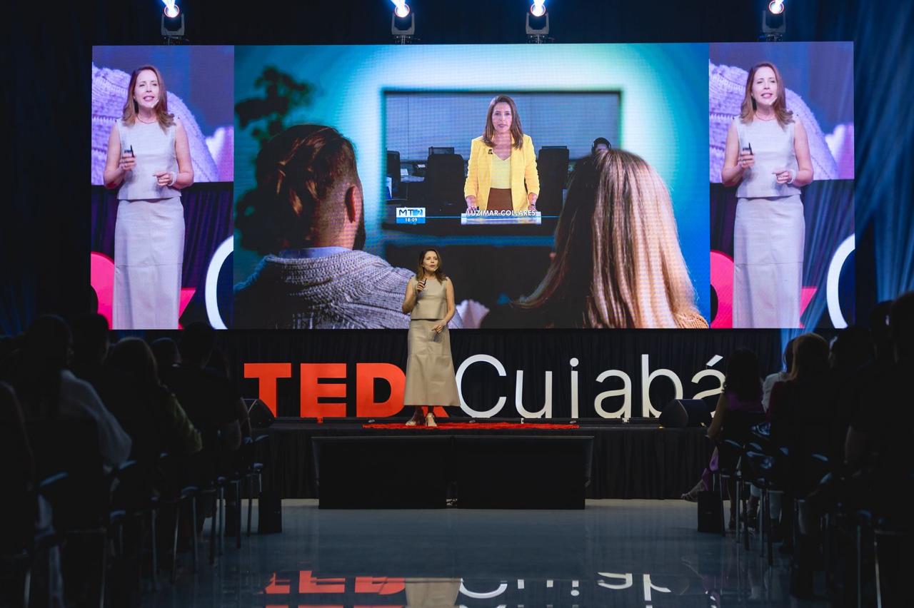 Luzimar Collares no palco do TEDx Cuiabá, diante do letreiro do evento